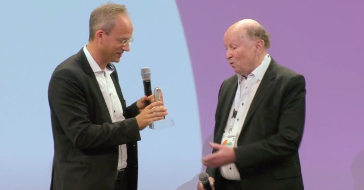 Dr. Thorsten Schmiege übergibt Gunther Oschmann den BLM-Ehrenpreis auf den LRFT24 (Bild: BLM / Lokalrundfunktage 2024 Livestream)